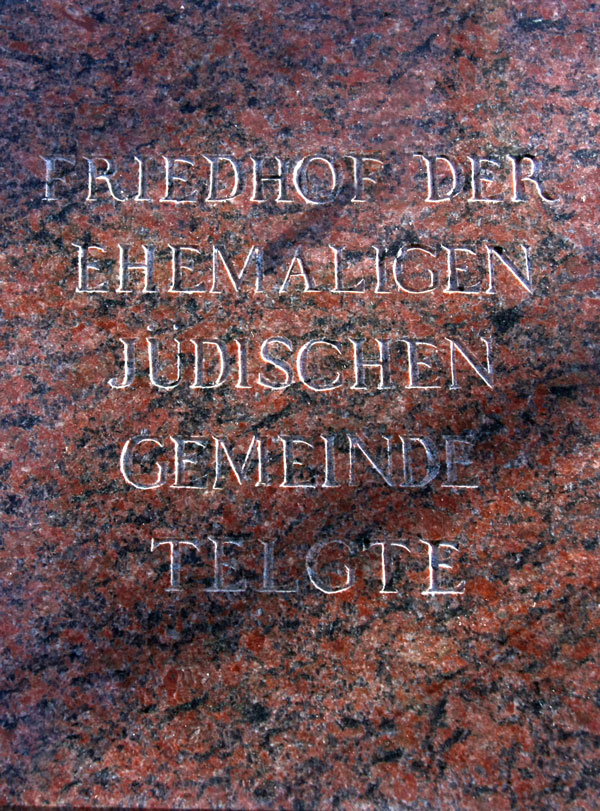 A red marble memorial slab with the inscription “Cemetery of the former Jewish community in Telgte” in capital letters.