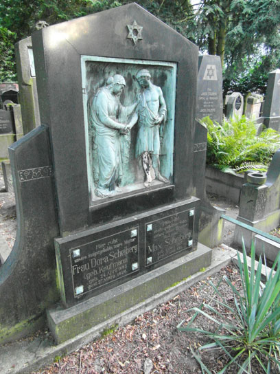 Large gravestone with oxidized copper relief of a woman and a man.